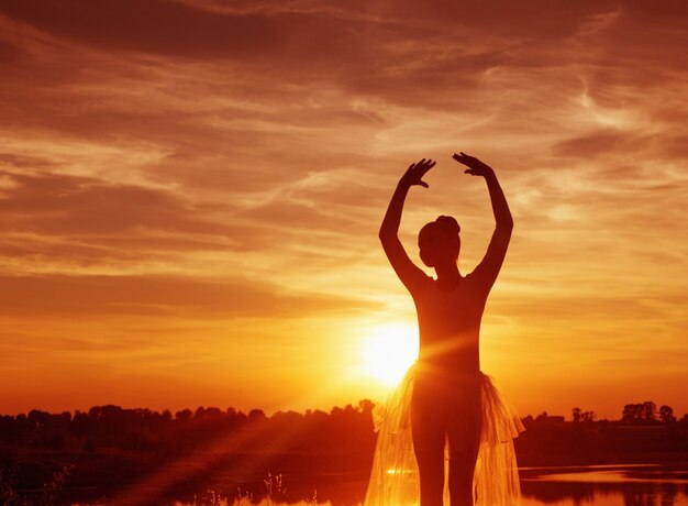 Foto silhueta de uma bailarina ao pôr do sol ao ar livre