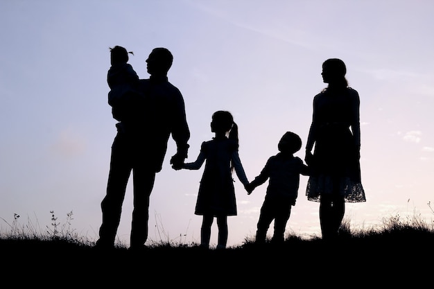 Silhueta de uma família feliz com filhos na natureza