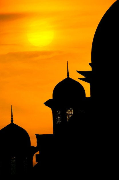 Foto silhueta de uma mesquita contra o céu durante o pôr do sol