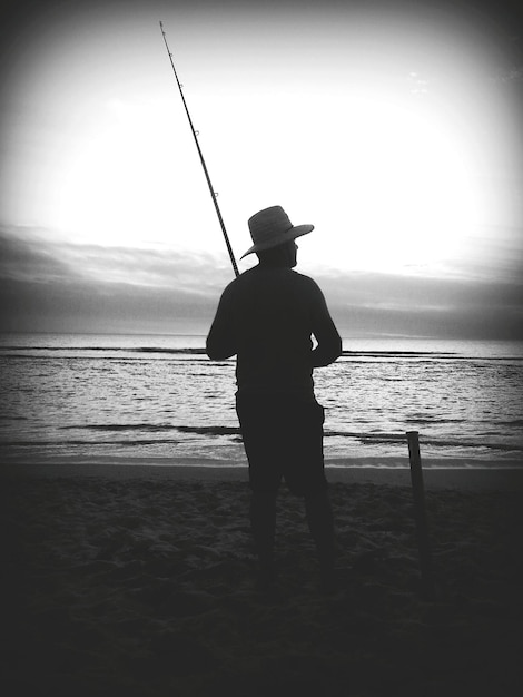 Foto silhueta de uma mulher de pé na praia