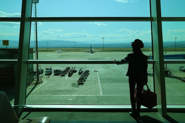 Silhueta de uma passageira esperando o embarque no aeroporto