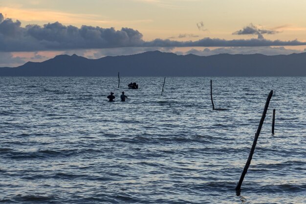 Foto silhueta de veleiro no mar contra o céu durante o pôr do sol