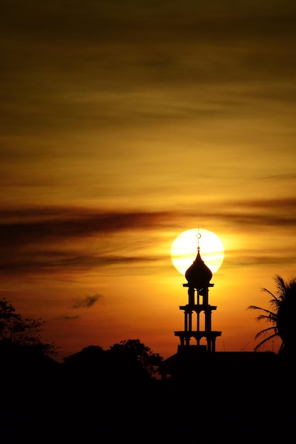 Silhueta do minarete da mesquita no céu do nascer do sol