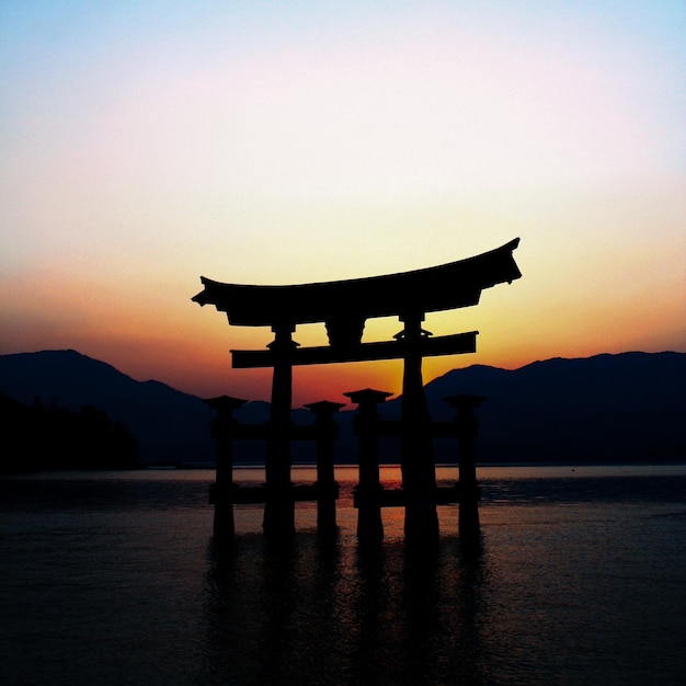 Silhueta do portão torii contra o céu durante o pôr do sol