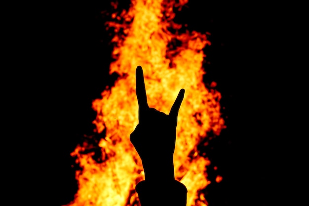 Silhueta do Rock and Roll sinal de mão contra o fogo