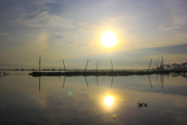 Foto silhueta do sol da manhã no meio do lago