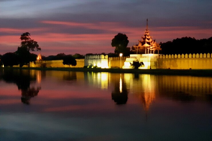 Foto silhueta del edificio junto al lago contra el cielo durante la puesta de sol