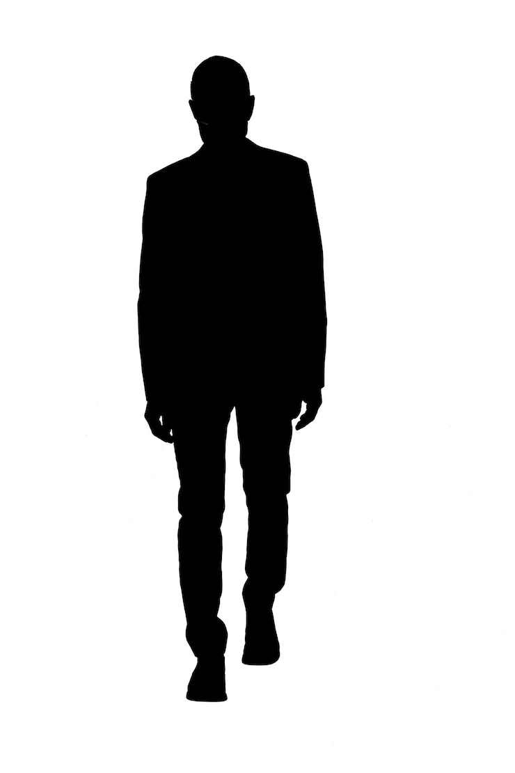 Foto silhueta frontal de um homem caminhando e vestido de terno
