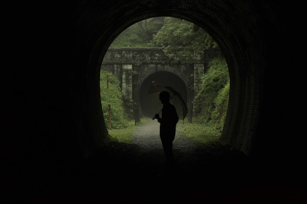 Foto silhueta de un hombre de pie en un túnel