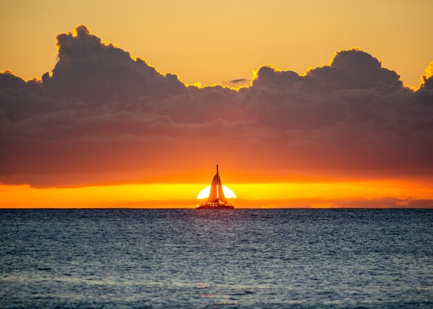 Foto silhueta de velero en el mar contra el cielo naranja