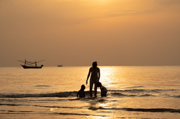 Foto silhueta vista da família tirar umas férias no tempo de verão com scape mar