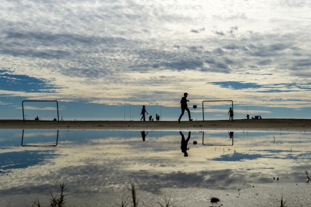 Silhuetas brincando na praia