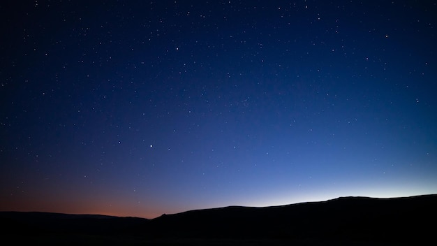 Foto silhuetas de colinas bajo un cielo estrellado por la noche perfectas para papeles pintados y fondos