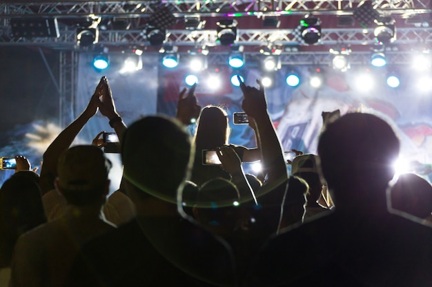 Silhuetas da multidão em concerto perto do palco