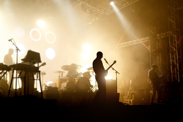 Foto silhuetas de bandas em um vocalista de concer com guitarra