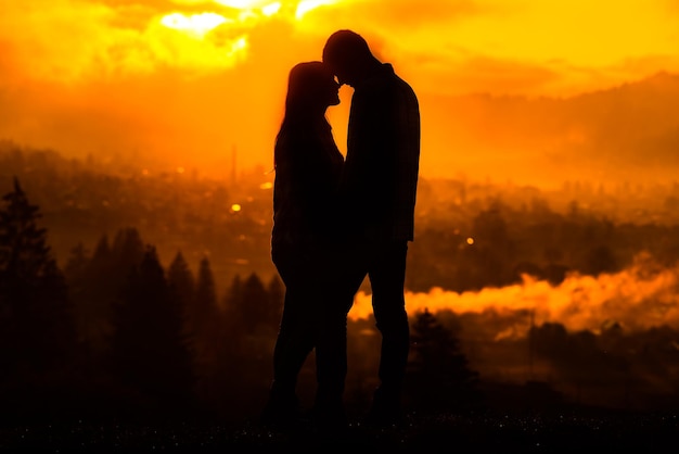Silhuetas de casal homem e mulher na natureza pôr do sol Conceito de amor de casal