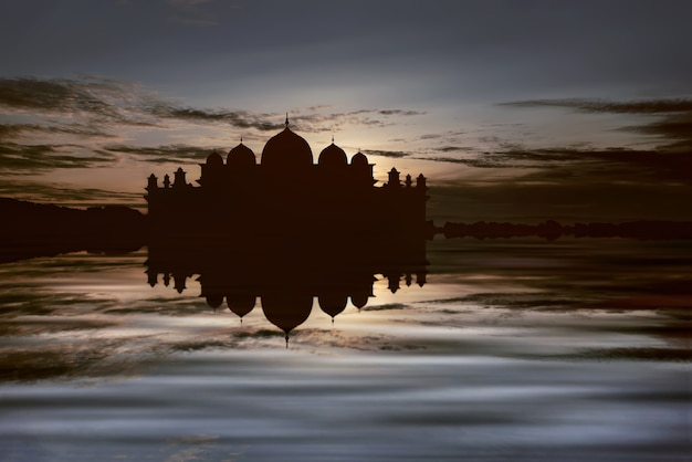 Silhuetas de grande mesquita com reflexo na água