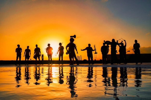 Silhuetas de músicos ao pôr do sol