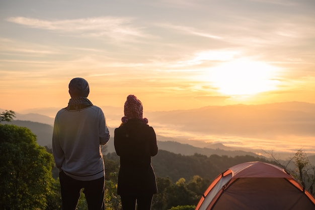 silhuetas de um casal apaixonado caminhantes no topo da montanha