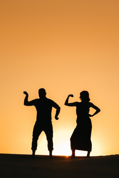 Silhuetas de um jovem casal feliz, cara e mulher