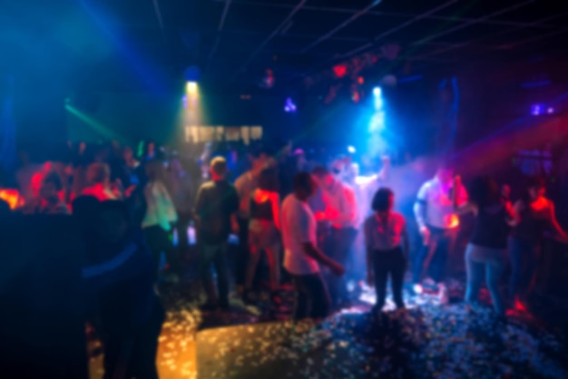 Silhuetas de uma multidão de pessoas dançando em uma boate na pista de dança em uma festa