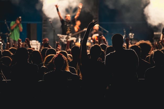 Silhuetas de personas en un concierto de música