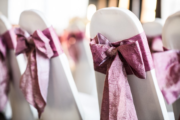 Silla blanca con lazo rosa para la ceremonia.