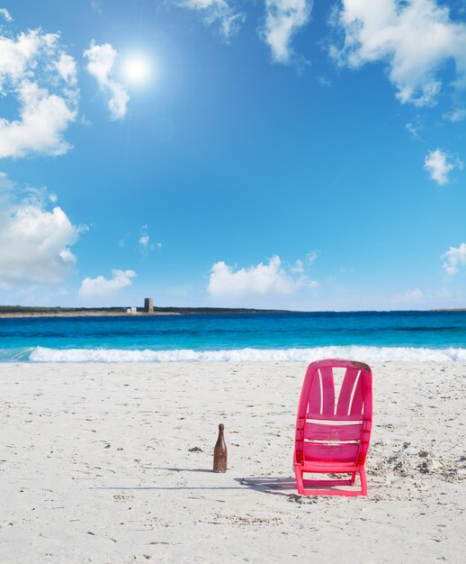 Silla y cerveza en la playa bajo el sol Rodada en Cerdeña Italia