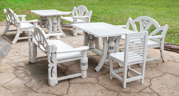 Silla de madera blanca al aire libre y estilo retro de mesa en la cafetería del césped