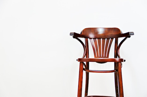 Silla de madera en fondo ligero de la pared con el espacio de la copia para su texto.