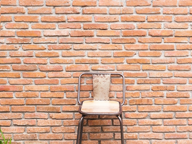 Silla de madera y fondo de pared de ladrillo naranja