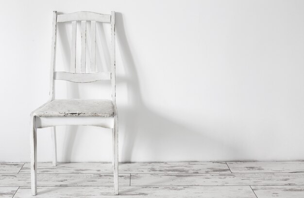 Silla de madera vieja blanca en interior vintage blanco