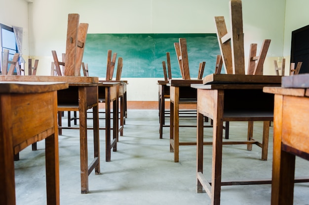 Foto silla y mesa en aula con fondo de tablero negro