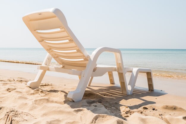 Silla de playa en la costa soleada en el fondo de la playa