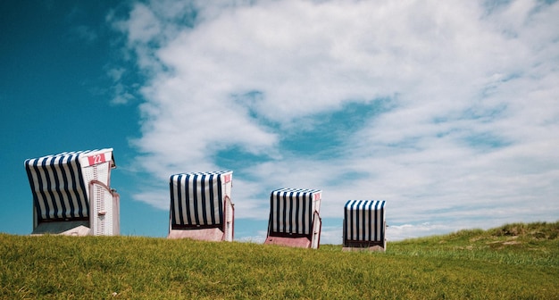 silla de playa con dunas y nubes de cielo azul verde gras