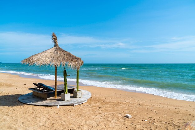 Silla de playa y sombrilla con fondo de playa de mar