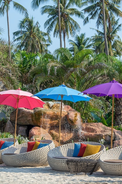 Silla de playa y sombrilla en la playa tropical cerca de la piscina en un día soleado, Tailandia. Concepto de naturaleza y viajes.