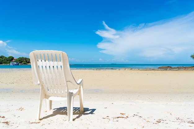 silla de playa vacía con vistas al cielo azul y el océano