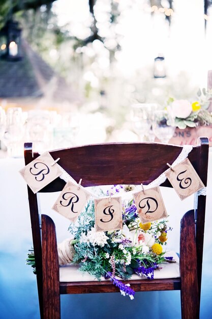 Foto silla con ramo de flores y texto de la novia en la mesa de comedor