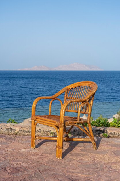 Silla de ratán en la playa tropical cerca del mar en Sharm El Sheikh, Egipto. Concepto de viajes y naturaleza.