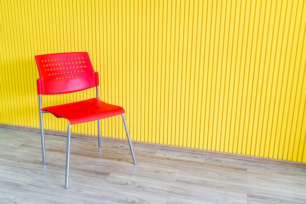 silla roja con pared amarilla