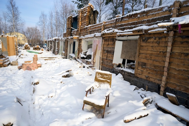 Silla vieja cubierta de nieve en una casa en ruinas.