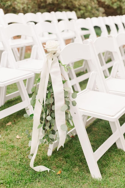 Foto sillas al aire libre decoradas con flores para la boda.