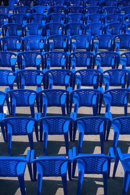 Las sillas azules se paran en la calle para un concierto.