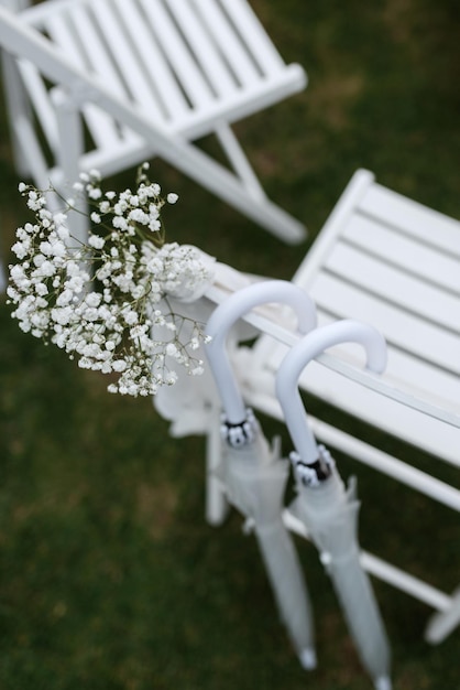 Sillas blancas de madera para ceremonia de boda sobre hierba verde