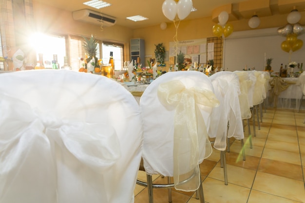 Sillas de boda en fila decoradas con cinta de color dorado