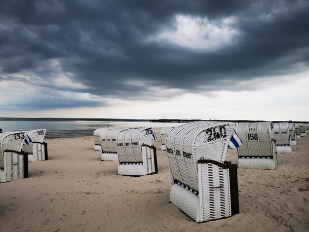 Sillas con capucha en la playa contra el cielo