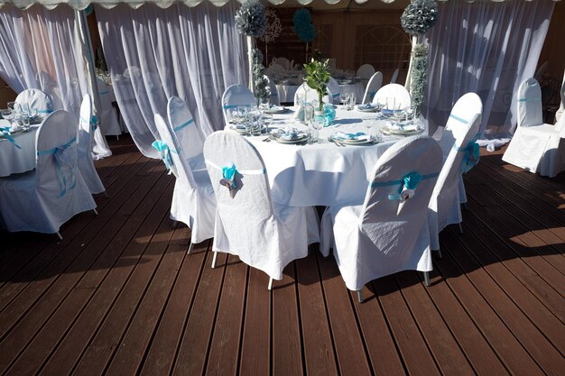 Sillas con cintas azules en la celebración de la boda en la terraza al aire libre