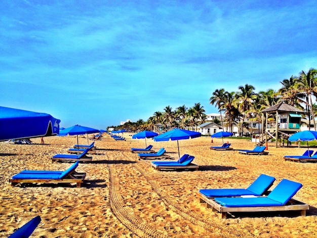 Sillas de descanso en la playa contra el cielo azul