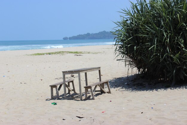 Sillas de madera junto a la playa durante el día.